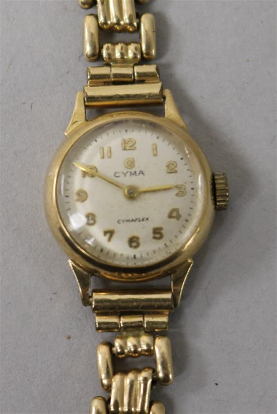 A ladys 9ct gold Cyma manual wind wrist watch on a gold plated bracelet.